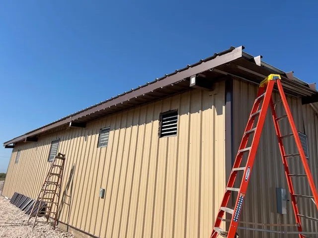 Side elevation of a tan metal operations building in Midland County during exterior completion, built by UTS BuildPros